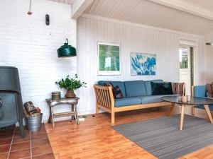 エーベルトフトにある6 person holiday home in Ebeltoftのリビングルーム(青いソファ、テレビ付)