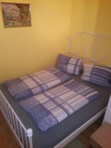 Schlafzimmer mit einem Bett mit lila und weißen Laken in der Unterkunft Ferienwohnung Familie Tost in Trins