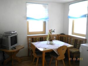 ein Esszimmer mit einem Tisch und einem TV in der Unterkunft Ferienwohnung Familie Tost in Trins