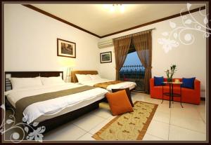 una habitación de hotel con una cama grande y una silla en My House Homestay, en Dongshan
