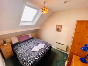 1 dormitorio en el ático con cama y ventana en Crescent Close, en Galway