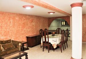 a dining room with a table and a couch at Hotel Velices in Buga