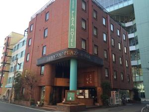 a red brick building with a sign in front of it at Nagano Plaza Hotel in Nagano