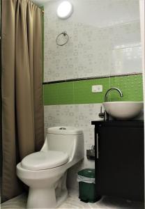 a bathroom with a white toilet and a sink at Hotel Velices in Buga +43 photos