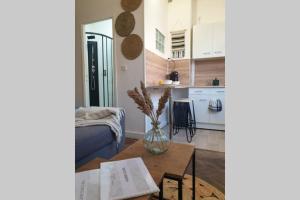 a kitchen and a living room with a vase on a table at Studio COSY en bord de mer in Dunkerque +12 photos