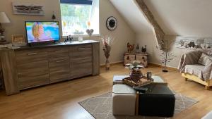 uma sala de estar com uma televisão de ecrã plano numa cómoda em Petit coin de Paradis em Cancale