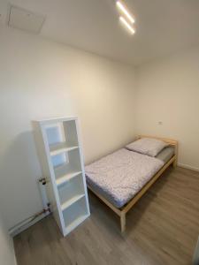 a small bedroom with a bed and a shelf at Sali Homes - 3BR Apartment with Kitchen in Kleve