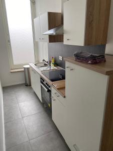 a kitchen with white cabinets and a stove top oven at Sali Homes - 3BR Apartment with Kitchen in Kleve