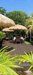 a wooden deck with two tables and umbrellas at The Pilot House in Rock Sound