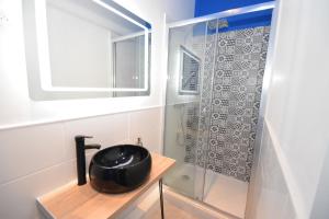 uma casa de banho com um lavatório preto e um chuveiro em DESIGN APPART - HYPER CENTRE - TRAM - FREE WIFI - leRelaisdOdile21 em Valenciennes