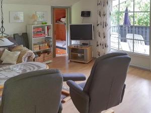 salon z 2 krzesłami i telewizorem w obiekcie Holiday home Sydals LII w mieście Neder Lysabild