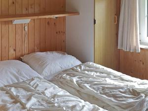 niepościelone łóżko w pokoju z oknem w obiekcie Holiday home Sydals LII w mieście Neder Lysabild