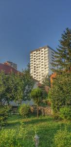 a tall white building with a sign in the grass at Passion by Nights & Smiles in Tuzla