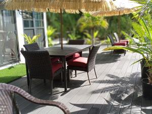 a wooden table with chairs and an umbrella on a patio at The Pilot House in Rock Sound