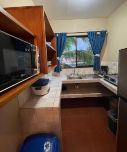 a kitchen with a sink and a large window at Apartotel Flamboyant in Jacó