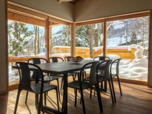 a dining room with a table and chairs at Asagiri Chalet Hakuba in Hakuba