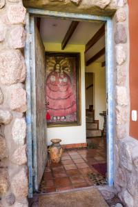 una puerta a una habitación con una pintura en la pared en VILLA APU CHICON (Apu Wasi & Inti Wasi) en Urubamba