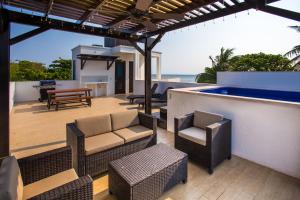 a patio with chairs and a bar with the ocean at Bella Luna Beach Home #64708 in West End