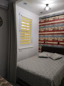 アドレルにあるАпартаменты с дизайнерским ремонтом Олимпийский паркのベッドルーム1室(ベッド1台付)、壁に旗が掛けられた窓が備わります。