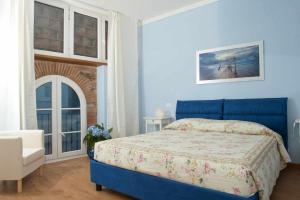 ein blaues Schlafzimmer mit einem Bett und einem Stuhl in der Unterkunft Villa Rossini in Lucca