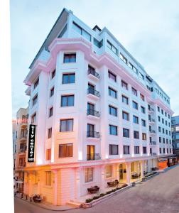伊斯坦布尔City Center Hotel Taksim İstanbul的街边的一栋白色大楼