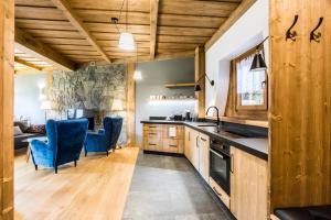 a kitchen with wooden cabinets and blue chairs at PREMIUM Apartament Krokus - Giewont View in Kościelisko