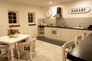 Belle Vue Park Villa في جبل تامبورين: مطبخ مع طاولة وساعة على الحائط