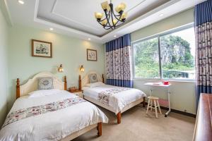 two beds in a bedroom with a window at Junshe Boutique Guest House-Complementary pick up servie for a 3-night stay in a deluxe room in Guilin +107 photos