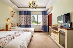 a hotel room with two beds and a tv at Junshe Boutique Guest House-Complementary pick up servie for a 3-night stay in a deluxe room in Guilin +122 photos