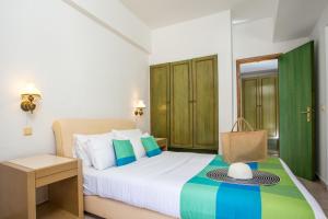 um quarto com uma cama, uma mesa e uma cama em Royal Aparthotel City Centre in Ilha de Rhodes