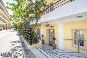 a building with a tree in front of it at Royal Aparthotel City Centre in Rhodes Town