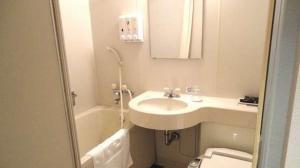 a bathroom with a sink and a toilet at Green Rich Hotel Nishitetsu Ohashi Ekimae in Fukuoka