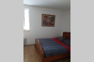 ein Schlafzimmer mit einem blauen Bett und einem Bild an der Wand in der Unterkunft Le 9 rue du moulin 4-5 personnes tout confort in Gripport