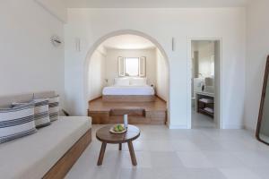a living room with a bed and a table at Ammothines Cycladic Suites in Naxos Chora