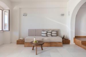 a bedroom with a bed with a candle on a table at Ammothines Cycladic Suites in Naxos Chora