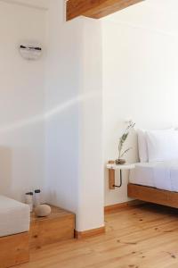 a bedroom with a white bed and a table at Ammothines Cycladic Suites in Naxos Chora