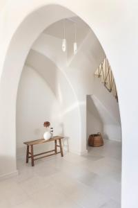 an arched hallway with a table and stairs at Ammothines Cycladic Suites in Naxos Chora