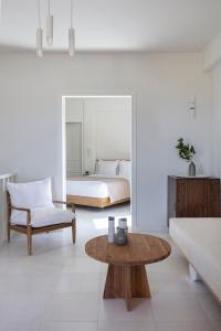 a bedroom with a bed and a table in a room at Ammothines Cycladic Suites in Naxos Chora