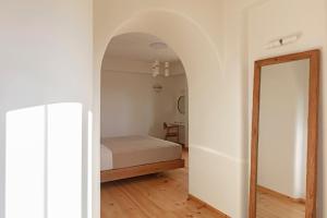 a bedroom with a bed and a mirror at Ammothines Cycladic Suites in Naxos Chora