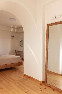 a bedroom with a bed and a mirror at Ammothines Cycladic Suites in Naxos Chora