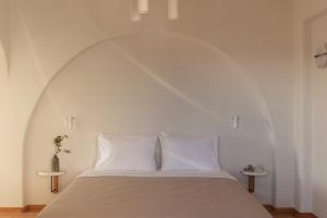 a bedroom with a bed with an arch above it at Ammothines Cycladic Suites in Naxos Chora
