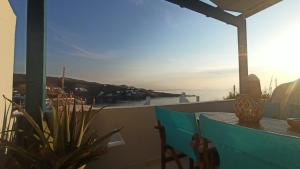 balcón con mesa y vistas al agua en Enjoy Cyclades studios & suites en Kíthnos