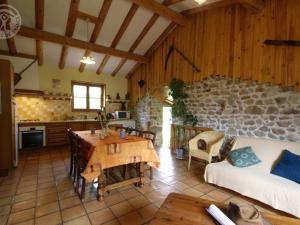 een woonkamer met een tafel en een stenen muur bij Gîte Jeansagnière, 4 pièces, 6 personnes - FR-1-496-98 in Mermond