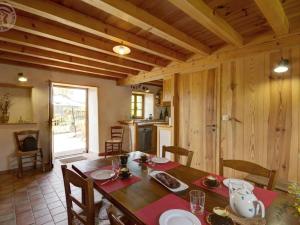 eine Küche und ein Esszimmer mit Tisch und Stühlen in der Unterkunft Gîte cosy avec jardin privatif et animaux acceptés - FR-1-496-119 in Virigneux