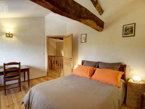 ein Schlafzimmer mit einem Bett, einem Tisch und einem Schreibtisch in der Unterkunft Gîte cosy avec jardin privatif et animaux acceptés - FR-1-496-119 in Virigneux