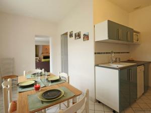 Il comprend une cuisine et une salle à manger avec une table et un réfrigérateur. dans l'établissement Gîte Montabard, 3 pièces, 5 personnes - FR-1-497-43, à Montabard