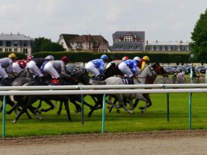 eine Gruppe von Pferden, die auf einer Rennstrecke rennen in der Unterkunft Appartement Chantilly, 3 pièces, 4 personnes - FR-1-526-3 in Chantilly