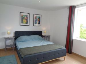een slaapkamer met een bed met 2 tafels en een raam bij Gîte Maringes, 3 pièces, 4 personnes - FR-1-496-174 in Maringes