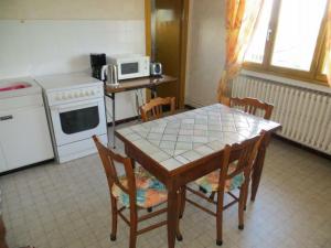 eine Küche mit einem Tisch, Stühlen und einer Mikrowelle in der Unterkunft Gîte Lorette, 3 pièces, 2 personnes - FR-1-496-76 in Lorette