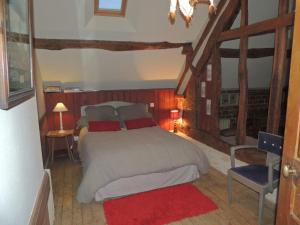 - une chambre avec un lit et un tapis rouge dans l'établissement Gîte Écouves, 2 pièces, 5 personnes - FR-1-497-122, à Forges